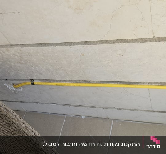 צינור גז צהוב מותקן על קיר מרוצף